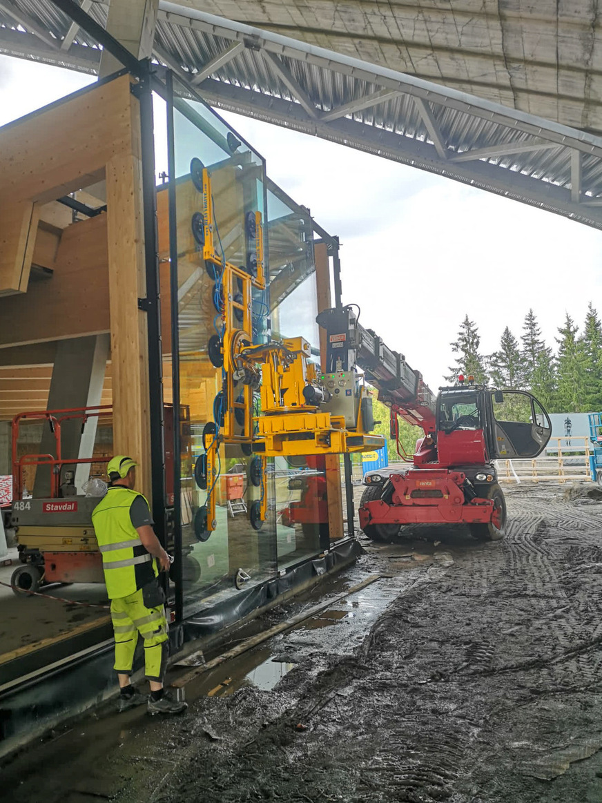 Installation of 680 kg glass panes on muddy ground.