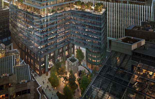 An aerial view of modern glass buildings surrounding a small historic stone tower and a green courtyard. - © Miller Hare